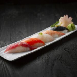 Elegant sushi platter featuring assorted seafood sushi on dark wood table.